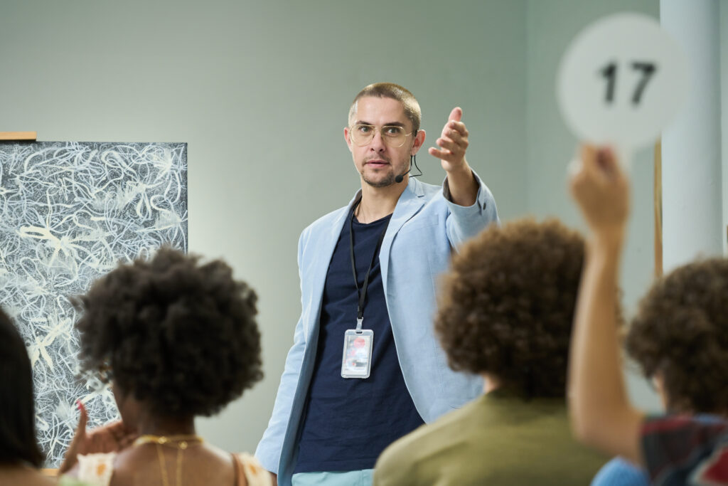 Man pointing at one of auctioneers